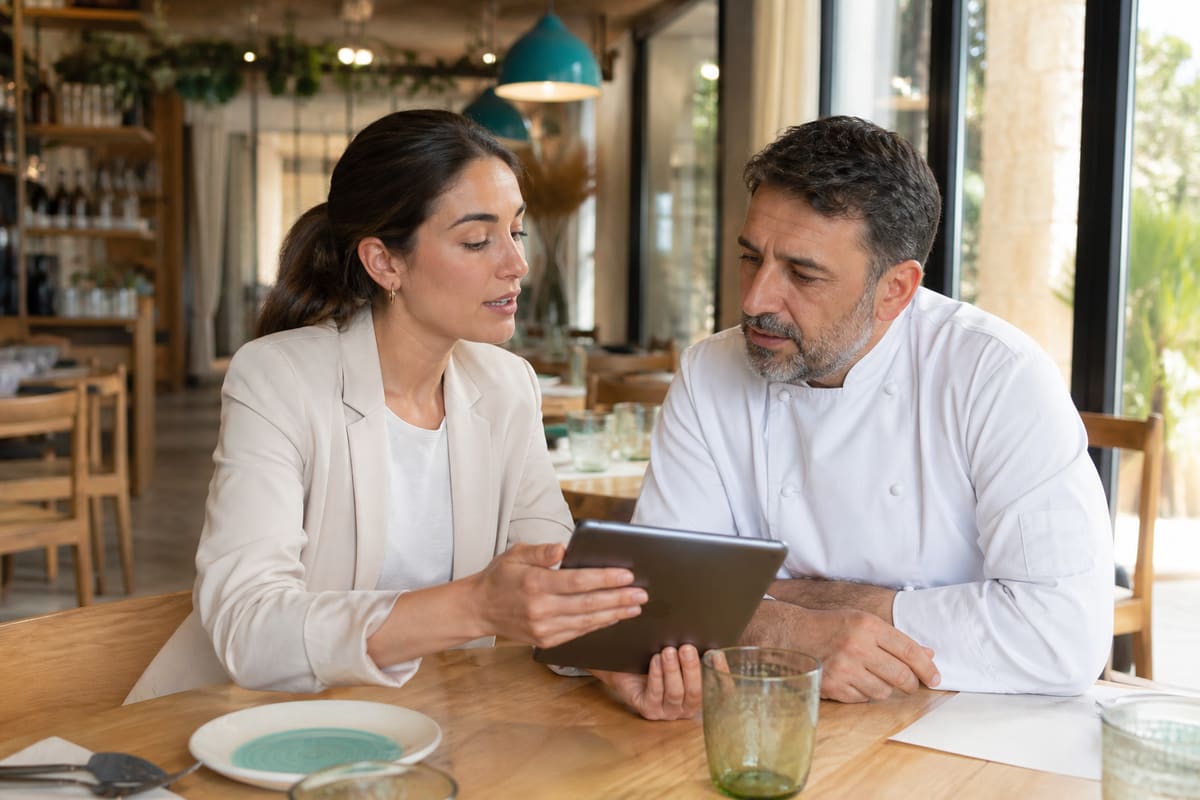 Comercial mostrando una auditoría digital al propietario de un restaurante